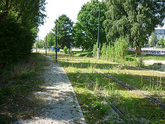 Ein Durchgang durch die Vegetation beim Rathaus Renens, mit Blick in Richtung Bahnhof Renens